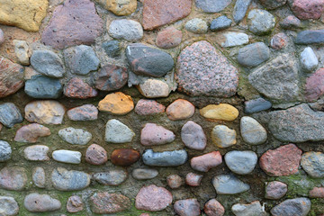 Background from large multi-colored stones. Antique stone road. Medieval stone road