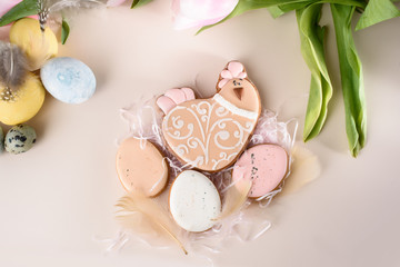 Easter gingerbread in the form of eggs and chicken with feathers on a light background.