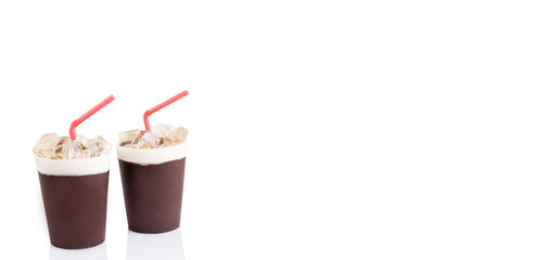 Two desserts in the form of a glass of drink with a tube on a white background.