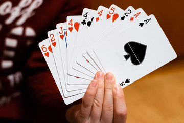 A person holding and showing a set of poker playing cards