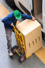 delivery courier worker with packages boxes with boxcar for delivering in city