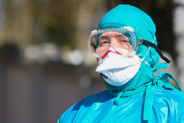 POLTAVA, UKRAINE - MARCH 13, 2020: Doctor in Special Protective Suit Disinfects Coronavirus Bus