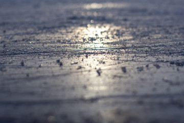 Sunset ice rink scratches, selective focus.