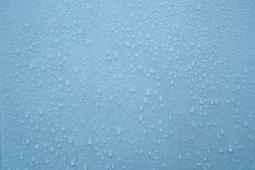 In selective focus many droplets on blue wall with wet pattern for backdrop texture