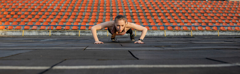 Fototapeta premium Female athlete preparing legs for cardio workout. Fitness runner doing warm-up routine. woman runner warm up outdoor. athlete stretching and warming up on a running track in a stadium