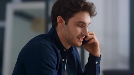 Closeup smiling man talking mobile in office. Cheerful guy having phone call - Powered by Adobe