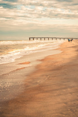 Stretch of Beach with Pier in Distance in Late Afternoon