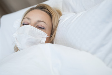 Sick woman lying in bed with high fever. Virus infection.