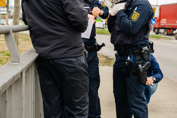 Unrecognizable German Polizei Police officers checks people at the border crossing in Kehl from...