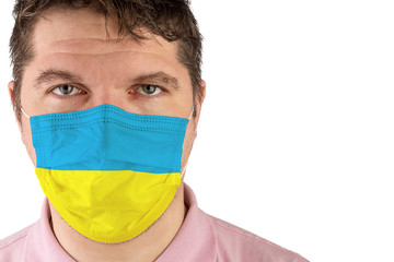 Portrait of adult caucasian man who wears protective mask on his face against influenza and protect health from bacteria. Flag of Ukraine.