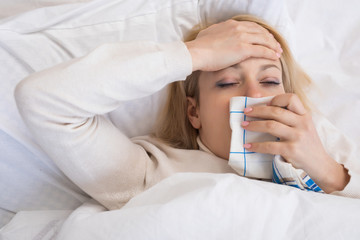 Sick woman lying in bed with high fever. Virus infection.