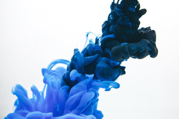 Mischung aus schwarzer und klassischer blauer Tinte in Wasser isoliert auf weißem Hintergrund.