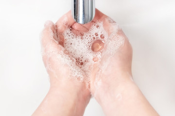 Fototapeta premium Washing hands with soap under the faucet with water