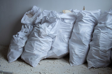 White construction bags of construction debris in a pile. Pollution concept. A pile of garbage in a landfill in a landfill. Illegal landfill.