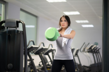 Fototapeta premium Woman training in a gym using a kettlebell