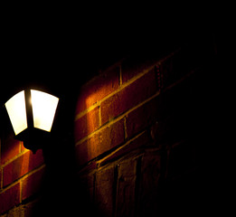 outside light in the dark of a brick wall