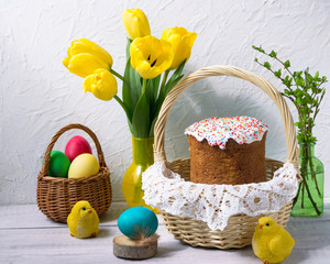 Fototapeta na wymiar Easter cake, multi-colored eggs and tulipson the holiday table.