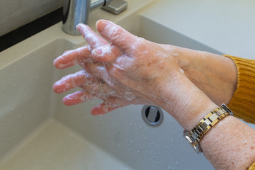 Fototapeta premium Woman washing her hands with soap in a bathroom