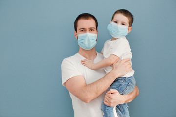 young father and his toddler son wearing surgical masks