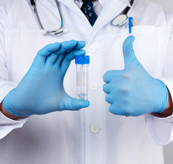 doctor in a white coat and blue sterile latex gloves holds a plastic jar for stool analysis