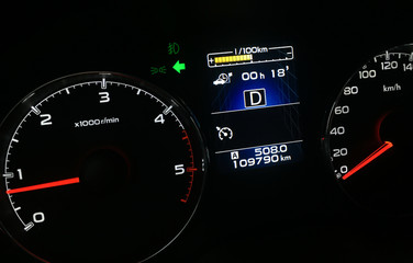 Diesel car tachometer and speedometer dashboard illumination at night. Fossil fuel cars economy problem