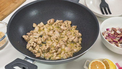 Chopped chicken meat on a frying pan close up
