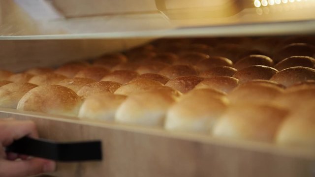 Close up of man's hand chosing buns. Fresh pastries. From the hot steaming buns. Wheat bread yellow.