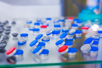 Caps, covers for medical glass bottles in showcase at pharmaceutical exhibition, pharmacy laboratory. Pharma industry, science, medicine, experiment and healthcare concept