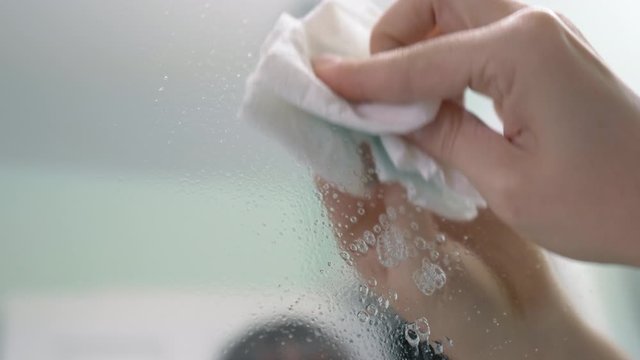 Spraying Window Cleaner on a Mirror and Wiping it Down