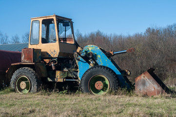 Old vintage bulldozer on countryside meadow in sunny day
