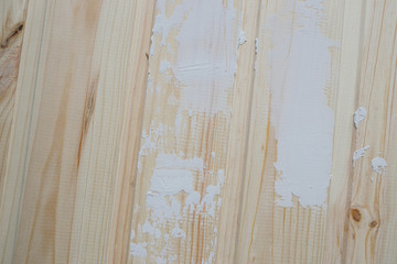 Fragment of the board partially painted with white paint.