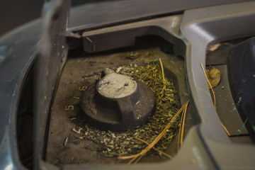 Dirty knob of robotic lawnmower, motorized lawnmower being serviced on a table after a year of use...