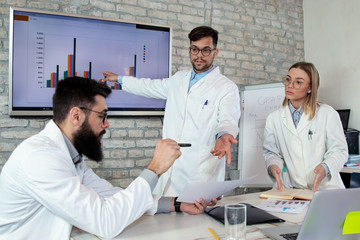 Doctors and medical researchers on conference meeting, discussing possible solutions for resolving a world health crisis. Health and medical care concept. Selective focus.