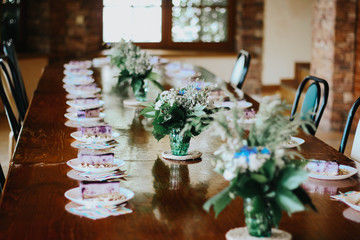 serving wooden table with cheesecakes and flowers brown color
