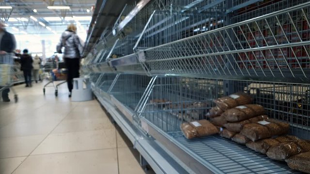 People walk by empty shelves in supermarket, timelapse