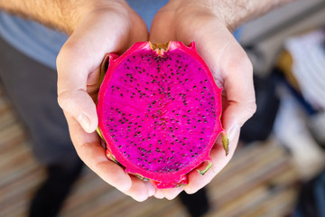 Pitahaya dragon fruit in male hands. Multiple red dragon fruit Tropical fruit red pitahaya.