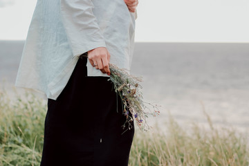 White wildflowers in the hands of a girl on the field