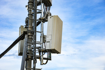 5G new radio telecommunication network antenna mounted on a metal pole providing strong signal waves from the top of the roof across big city 