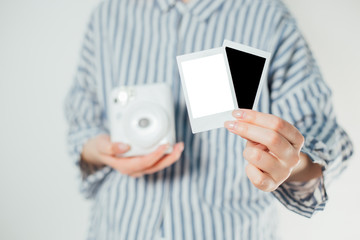 girl holds photo frames and a white camera