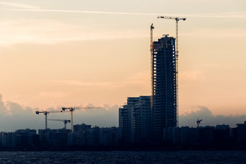Silhouettes of unfinished high-rise buildings after sunset