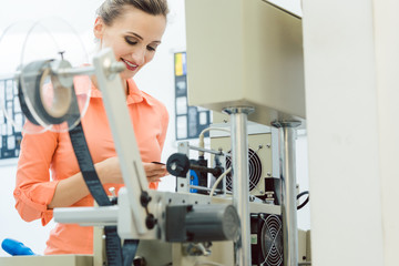 Worker checking textile label fresh from the printing machine