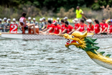 Dragon boat's head with racing team on the background - obrazy, fototapety, plakaty