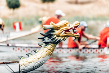 Dragon boat's head during the race, tinted photo - obrazy, fototapety, plakaty