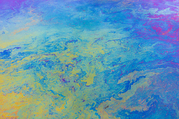 Spilled diesel fuel on surface on ocean water, close up, blue and yellow patterns. ,Spilled diesel fuel