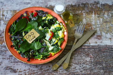 Selective focus. Note with the words cbd food in a pan with an omelet. Omelet with spinach and vegetables containing cannabis.