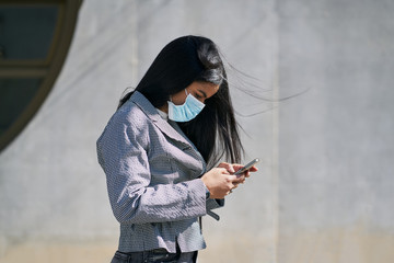 Girl with a mask to avoid contagion walking down the street. Coronavirus concept