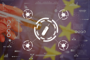 Concept tests in the European Union for the covid-19. Abstract syringe, virus icon on the background of a blurred hand in red gloves holds a flask with blood and the EU flag, graphs. Toned.