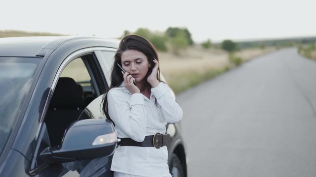 Pretty woman making call and having a problem with car serviceable