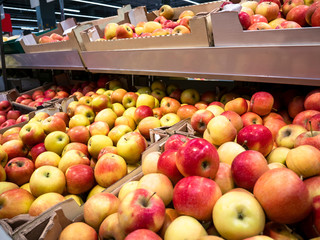 Red and yellow garden seasonal apples on shelves in the market. Sale of ripe apples in the store.