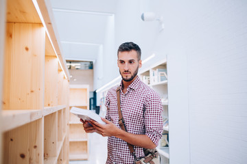 Young man choosing book in bookshop